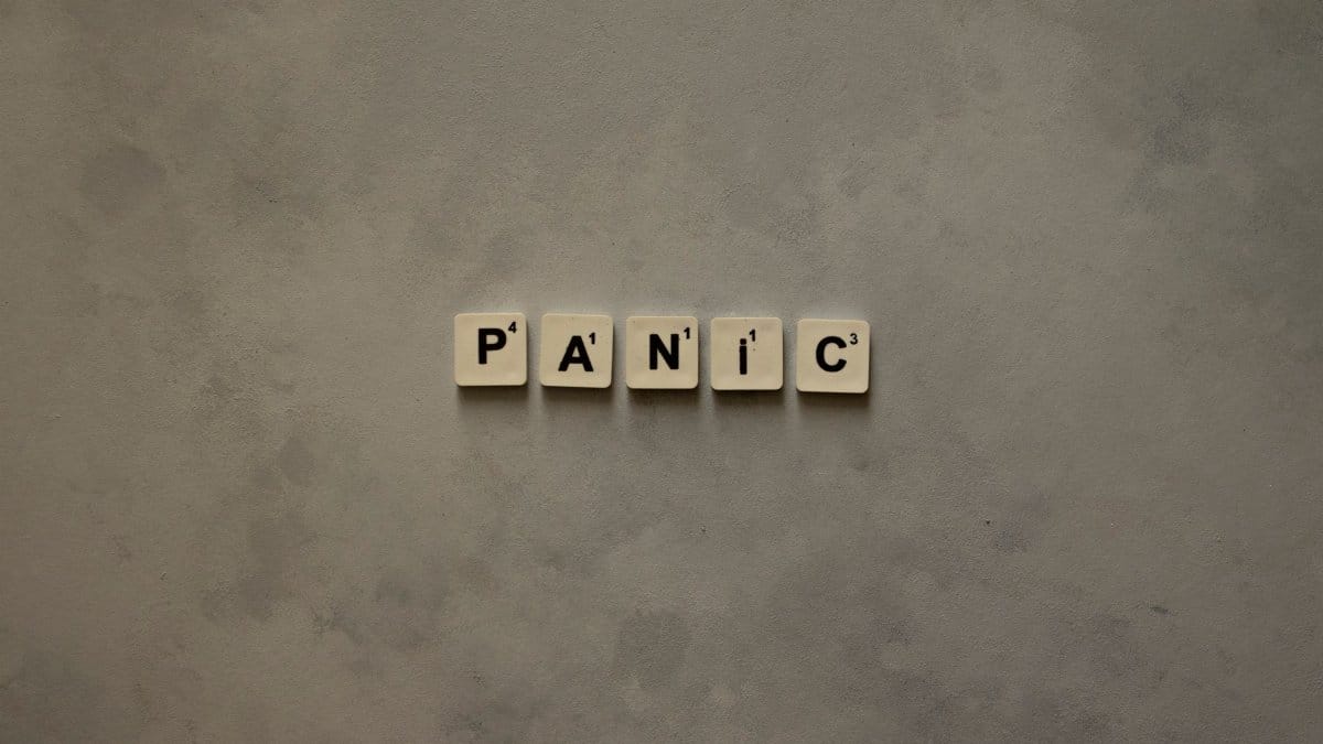 Scrabble tiles forming the word 'Panic' on a simple neutral background, symbolizing anxiety.