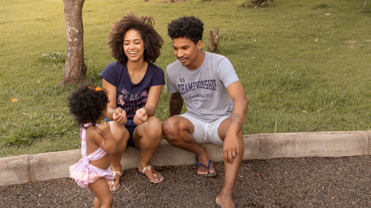 A family enjoys quality time in the park, depicting love and parenthood.