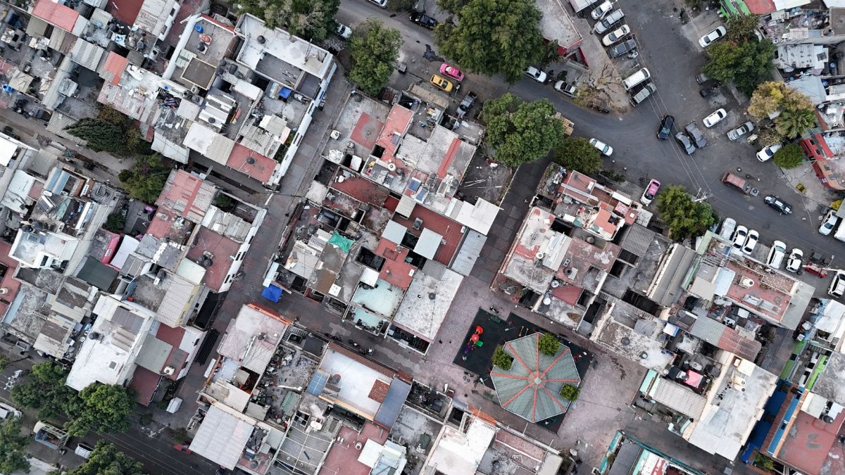 High-angle shot of densely packed urban residential area with streets and vehicles.