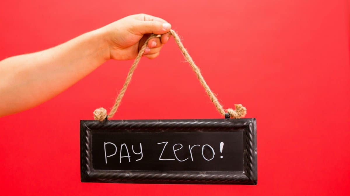 A hand holds a sign displaying 'Pay Zero' on a vibrant red background, emphasizing a free or zero-cost concept.