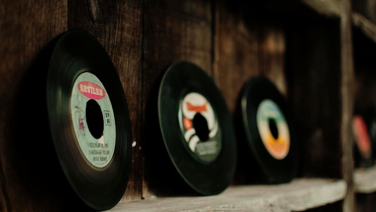 Collection of various retro vinyl records arranged on shabby lumber shelf in shop