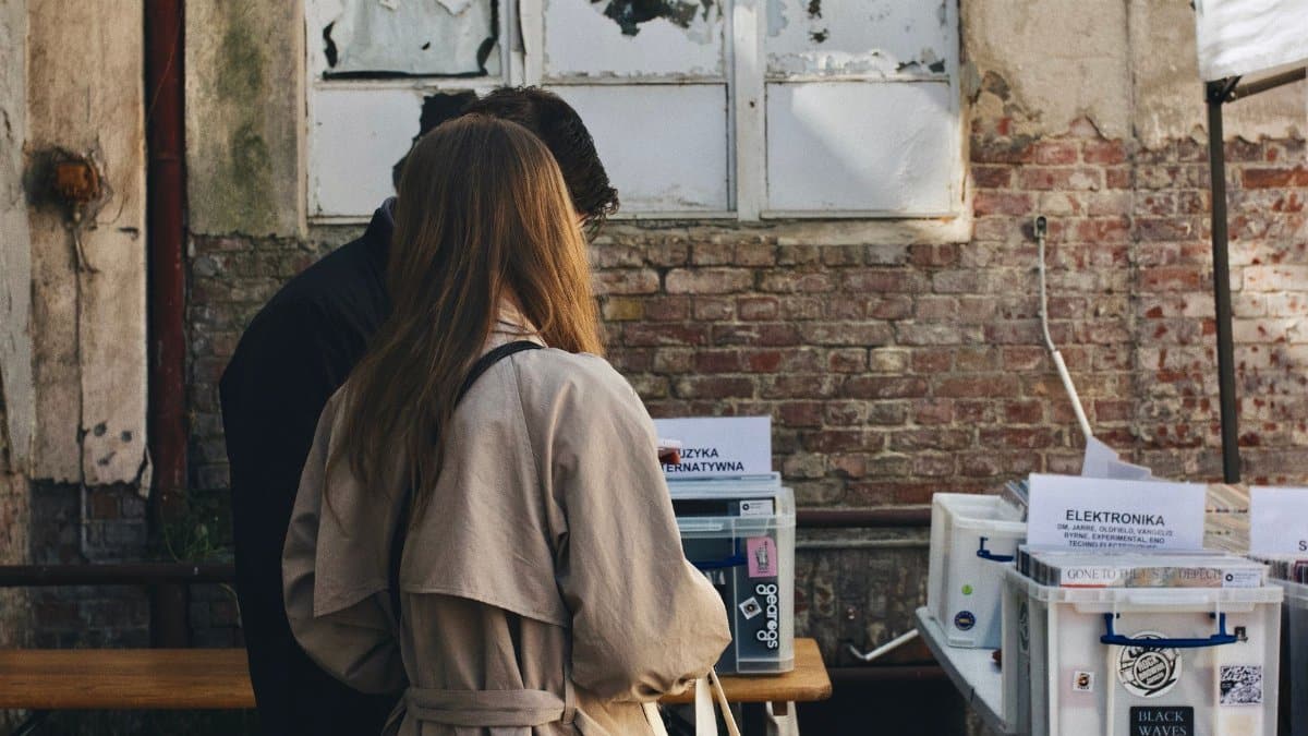 A couple browsing vintage vinyl records at an outdoor market in Szczecin, Poland.