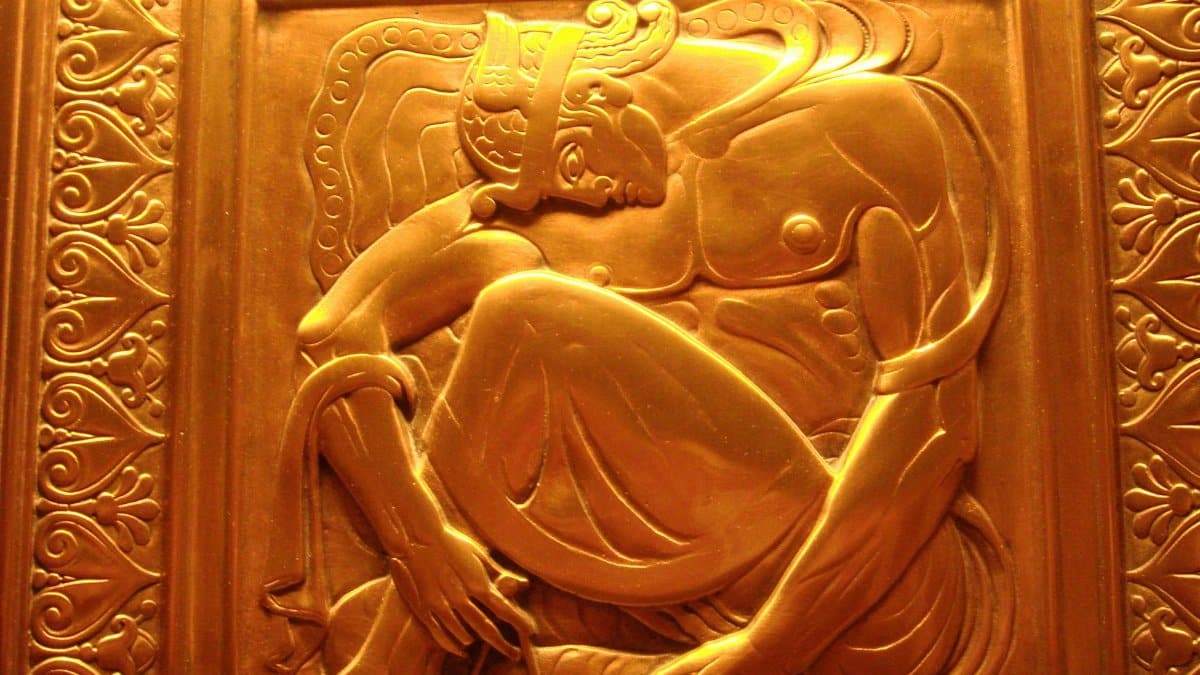 Art Deco gold relief sculpture depicting mythological figure in intricate detail.