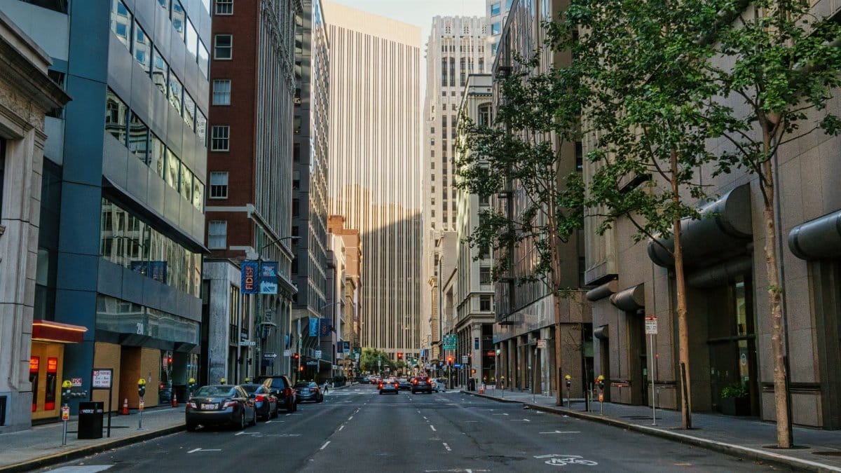 Lively downtown San Francisco street with buildings and cars during daytime.