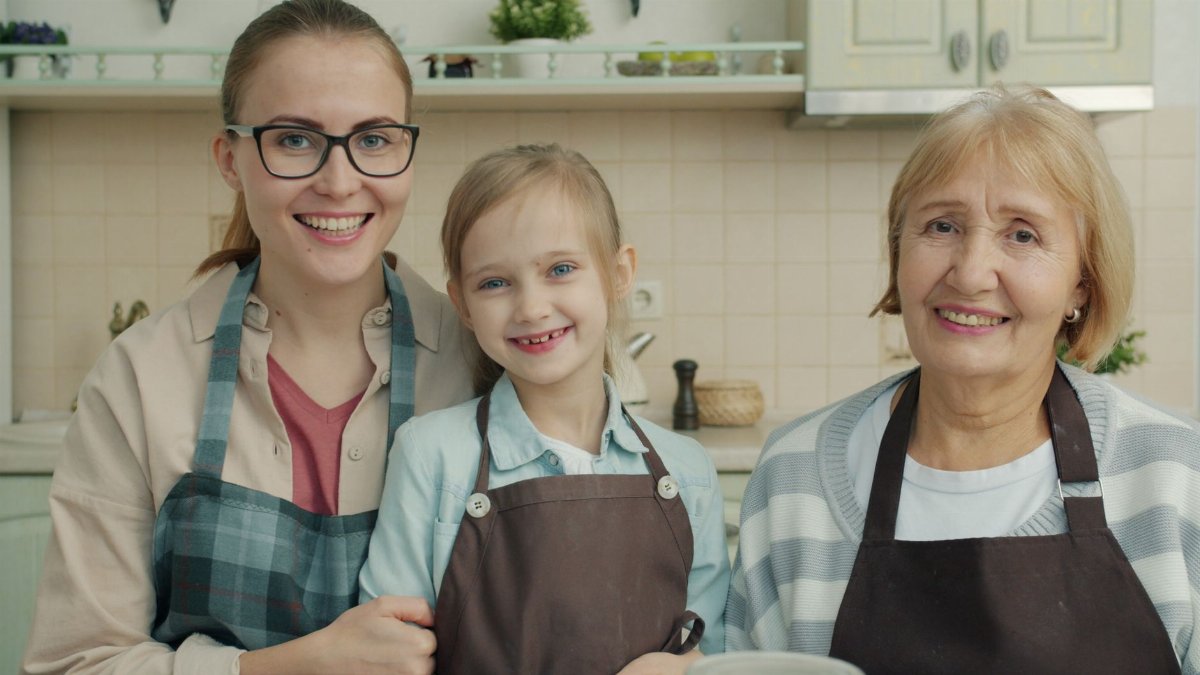 Happy family portrait of three generations cooking together.