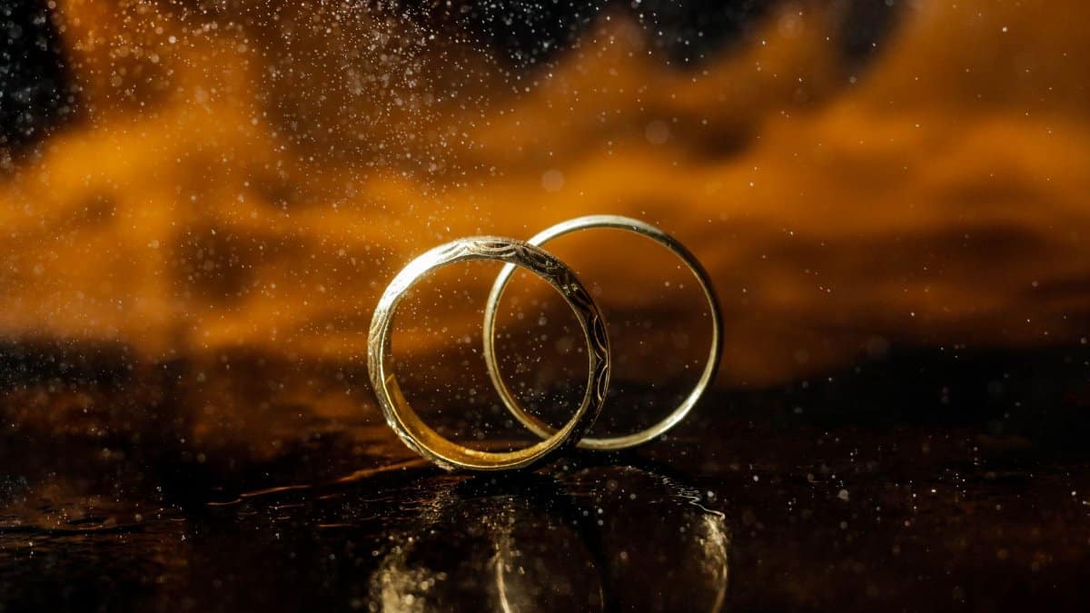 Stunning close-up of two gold wedding rings against a dramatic backdrop. Perfect for wedding and romance themes.