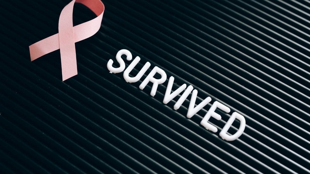 Pink ribbon and 'survived' text symbolize breast cancer awareness and survivorship.