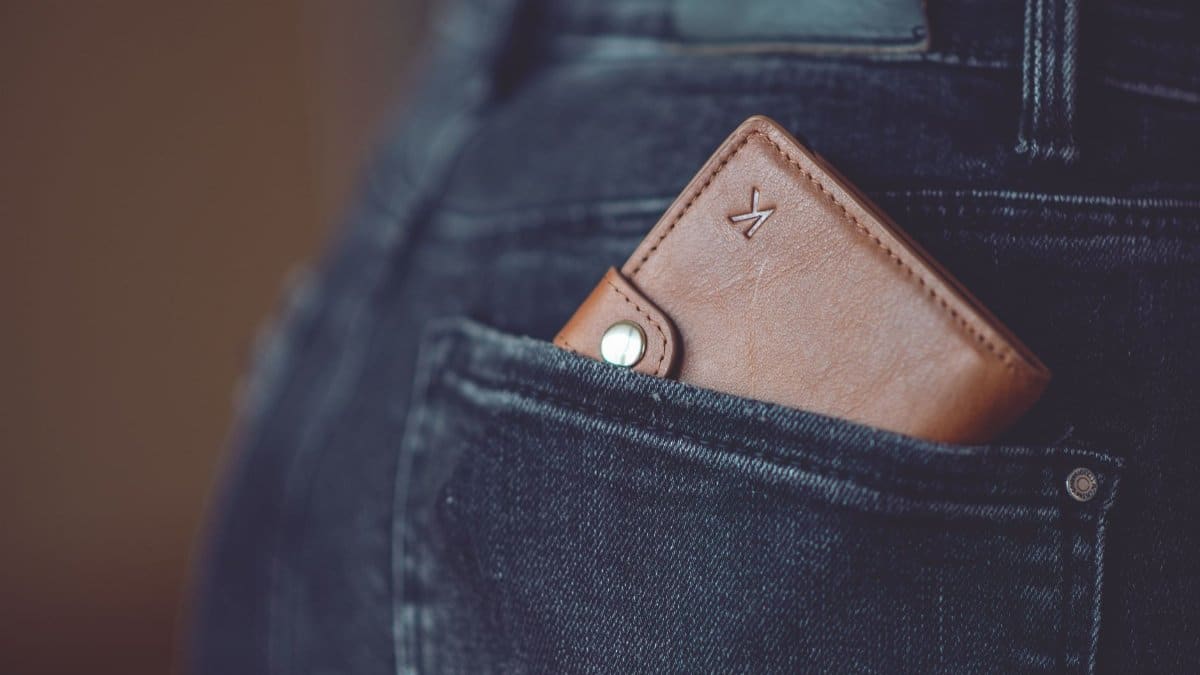 A stylish brown leather wallet partially visible in a jeans back pocket.