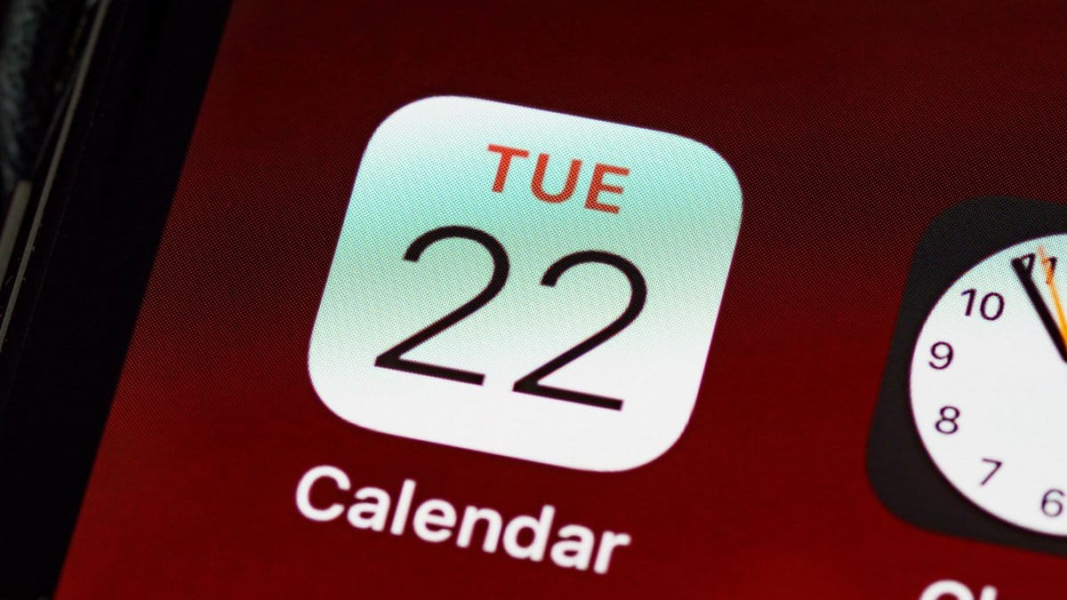 Detailed close-up of an iPhone home screen focused on the calendar app icon.