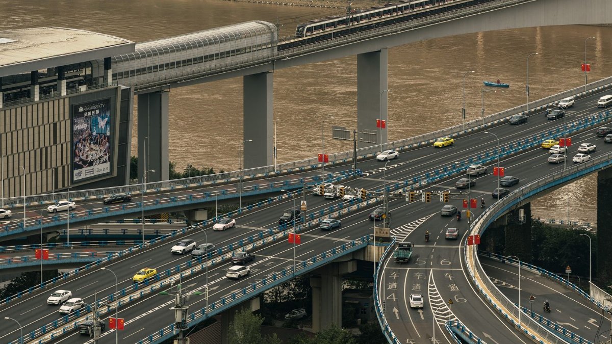 High-angle view of cars on a busy highway intersection near a river in an urban setting.