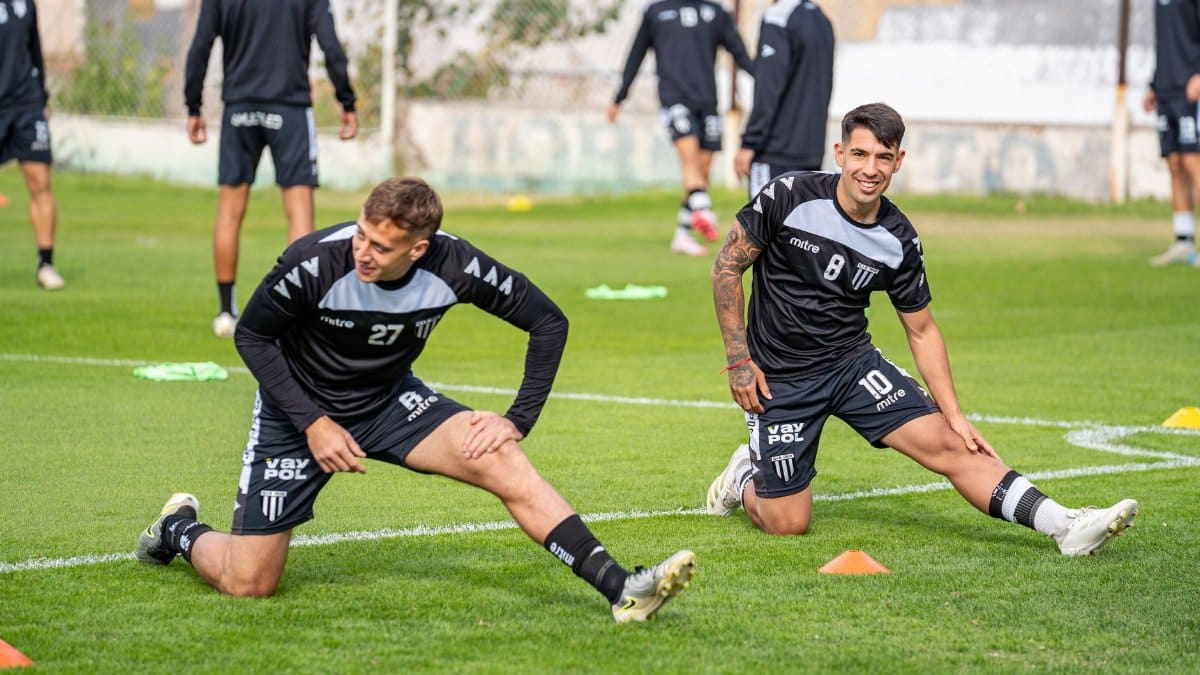 Soccer players warming up during a training session on the outdoor field.