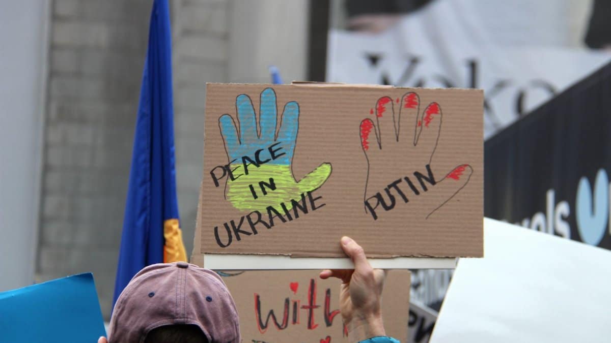 Crowd in Vancouver holding signs calling for peace in Ukraine during a protest.