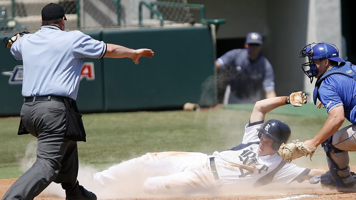 A thrilling baseball game moment as a player slides to home plate under pressure from the catcher.
