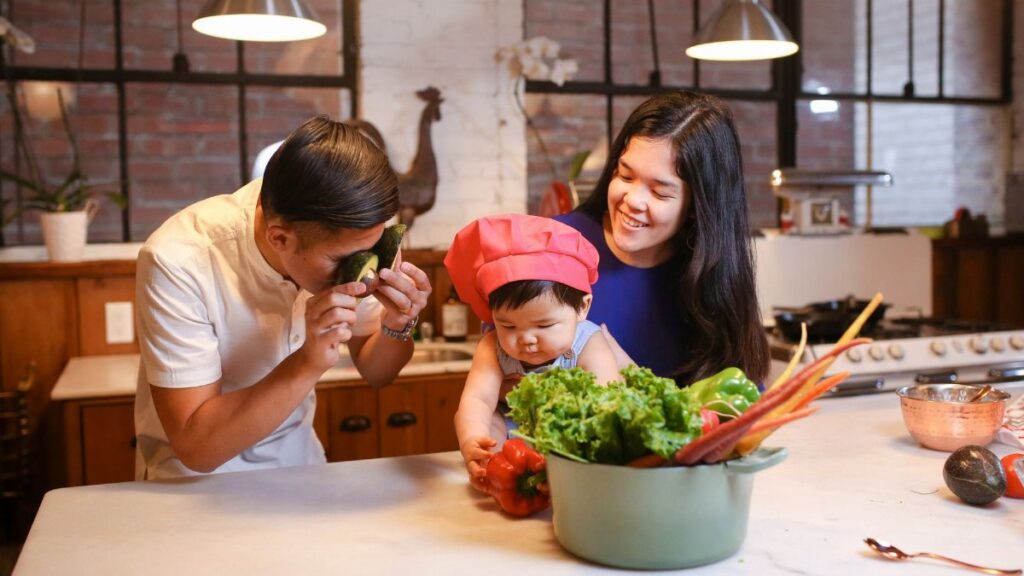 Asian family having fun cooking together with their child in the kitchen.