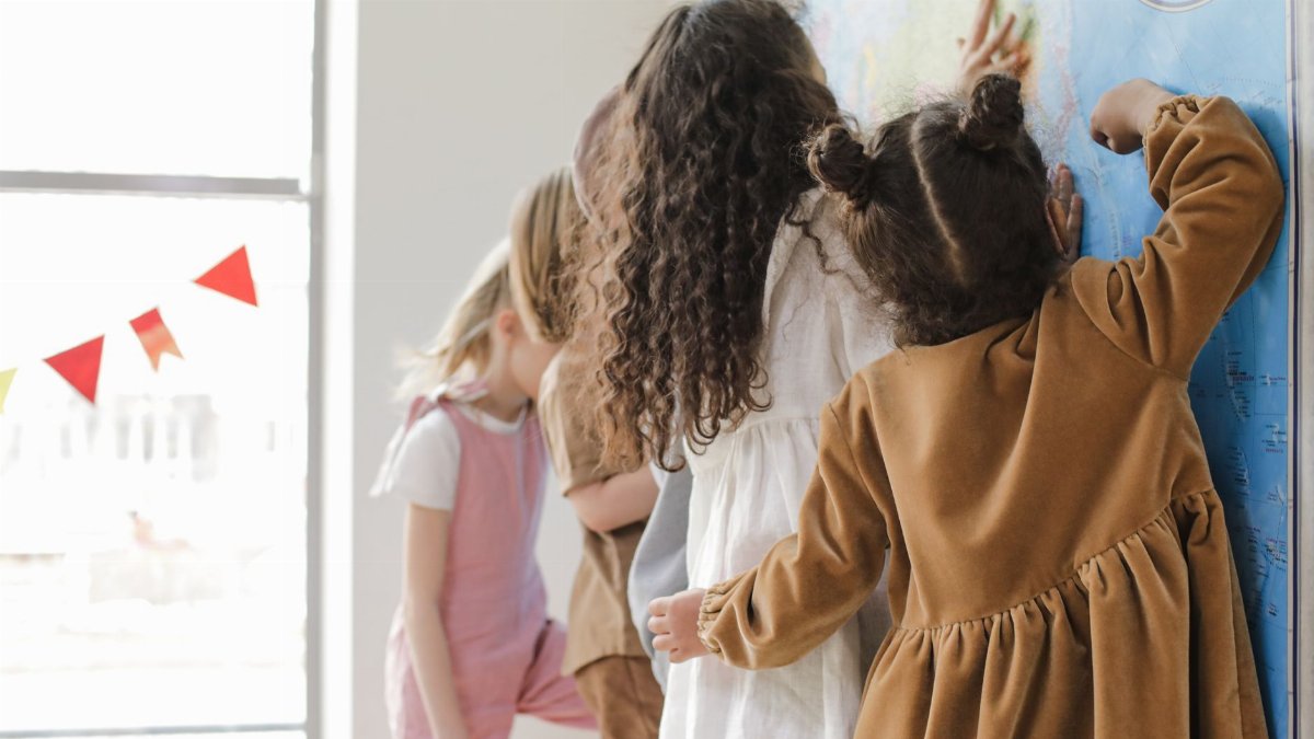 Young children learning geography with a map in a classroom setting.