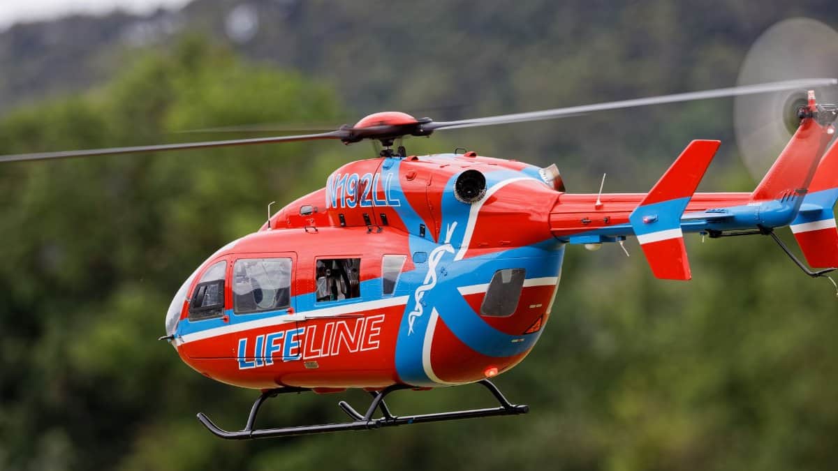 Close-up of a Lifeline helicopter in flight, showcasing its bold red and blue design.