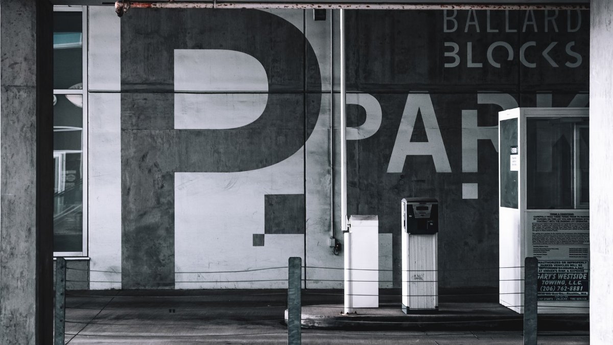 View of a modern urban parking garage in Seattle with graffiti and signage.