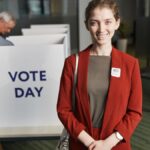 Woman in red suit at voting station, promoting civic engagement on election day.