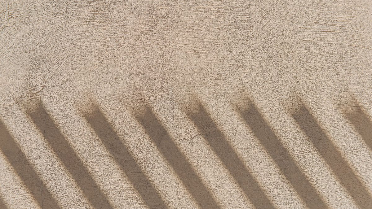 A close-up of shadows casting patterns on a textured wall, creating a dynamic visual effect.