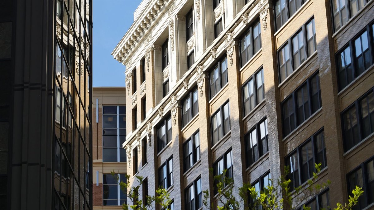 Facade of historic urban building with ornate details under a clear blue sky.