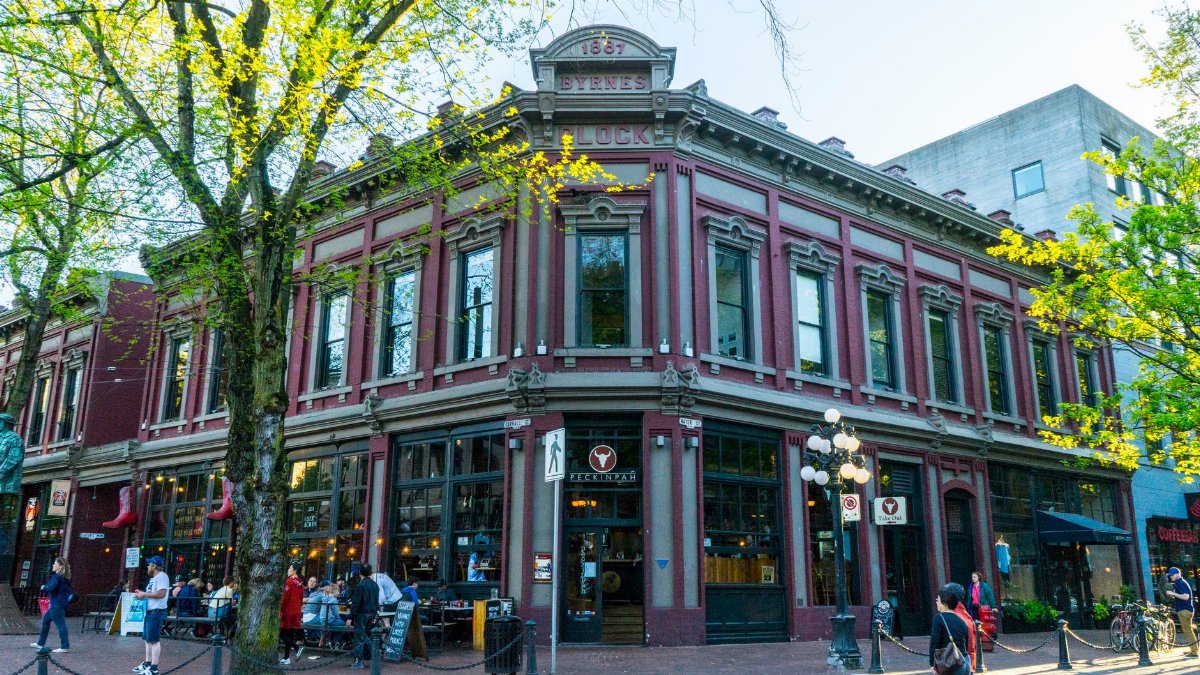 Charming Victorian architecture of Byrnes Block in a lively city street scene with bustling shops and cafes.