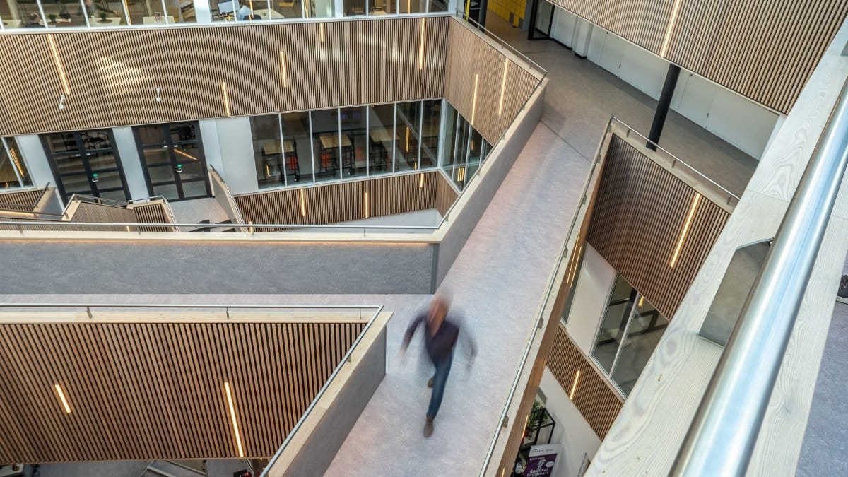 Blurred motion in a modern, geometric interior with wooden panels and open space.