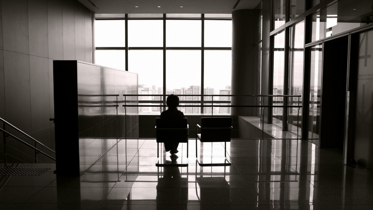 Black and white photo of a child sitting alone in a modern building in Tokyo.