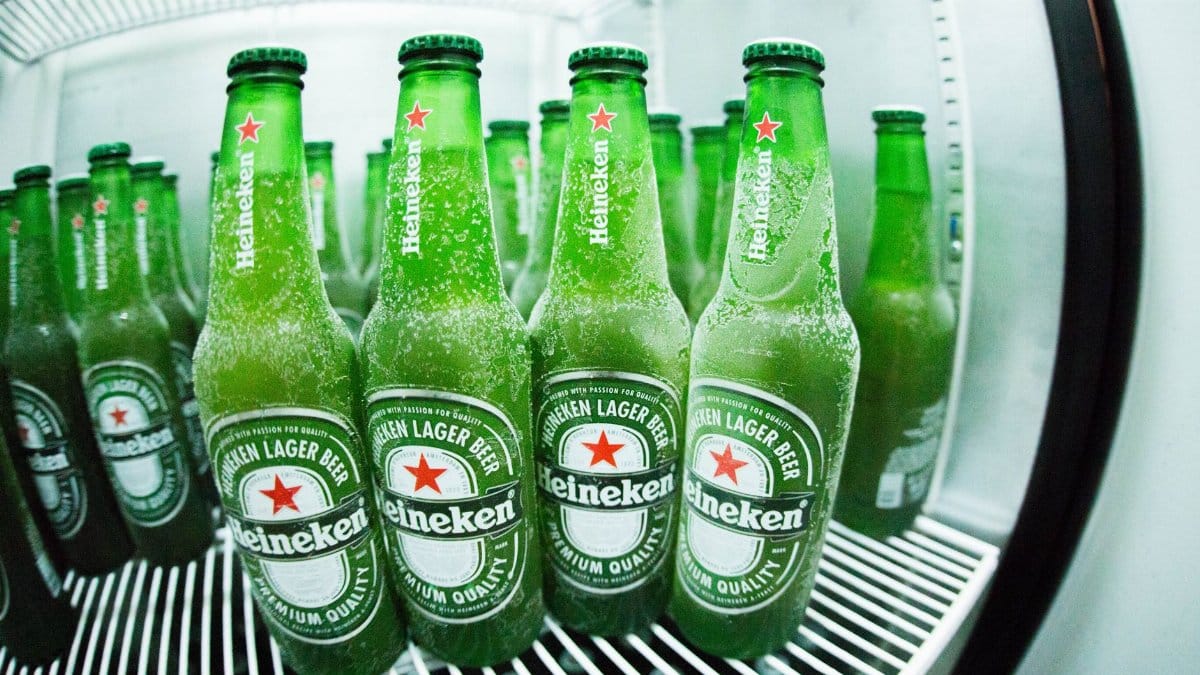 Frosted Heineken beer bottles in a refrigerator showcasing the refreshing coolness.