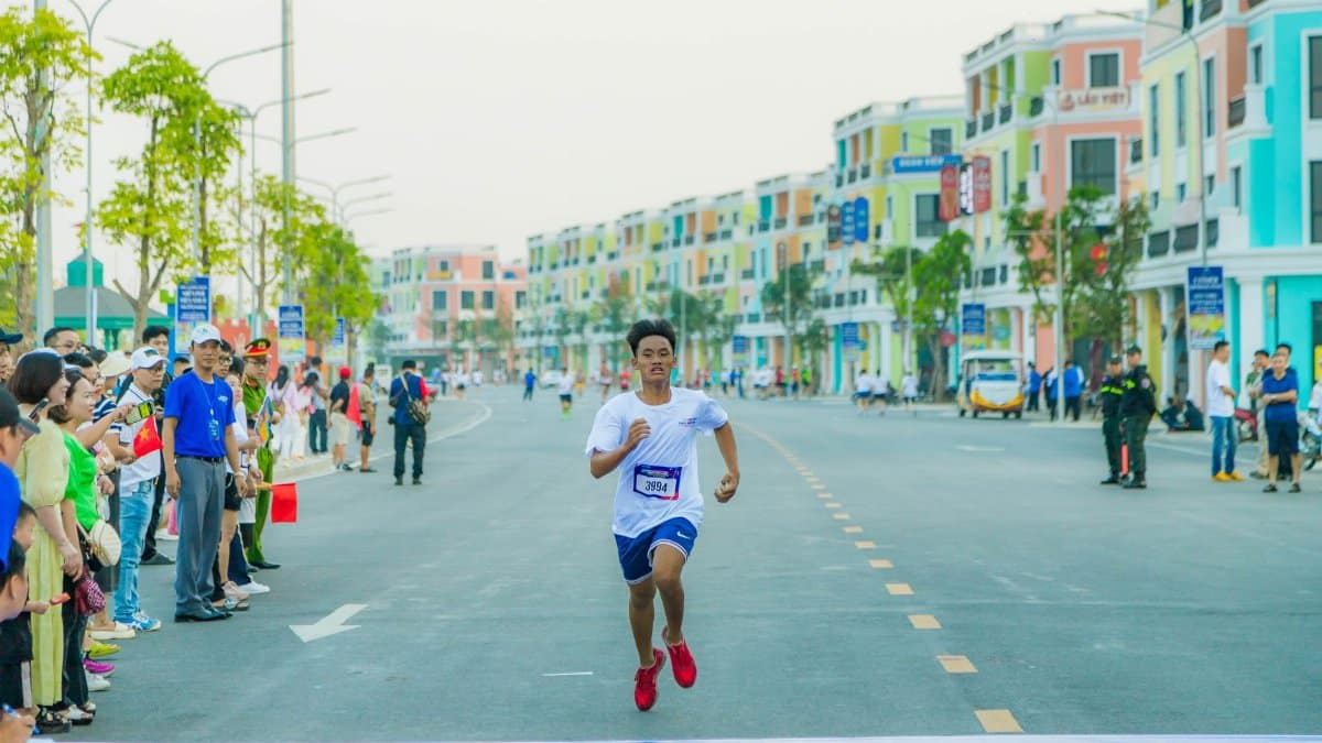 Runner reaching the finish line in a vibrant marathon in Hải Phòng's colorful streets.