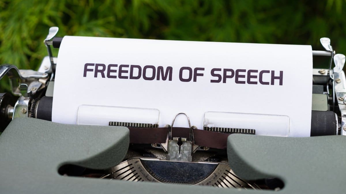 Close-up of typewriter with 'Freedom of Speech' message on paper, evoking themes of journalism and expression.
