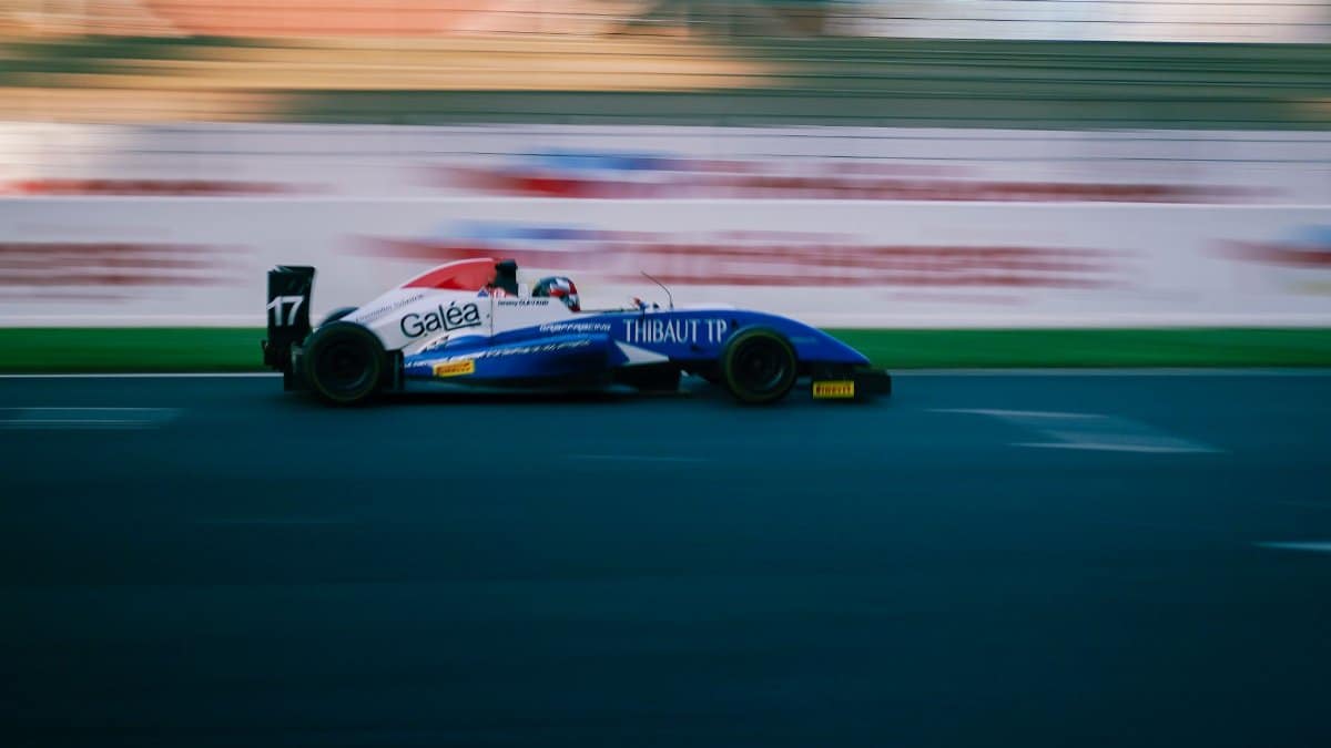 High-speed racing car on a circuit track showcasing motion blur and vibrant colors.