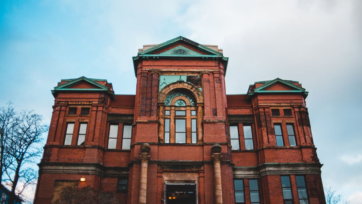A well-preserved historic red brick building showcasing classic architecture under a bright sky.