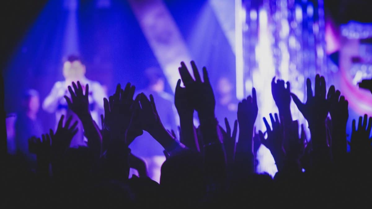Vibrant music concert scene with crowd and colorful stage lights.