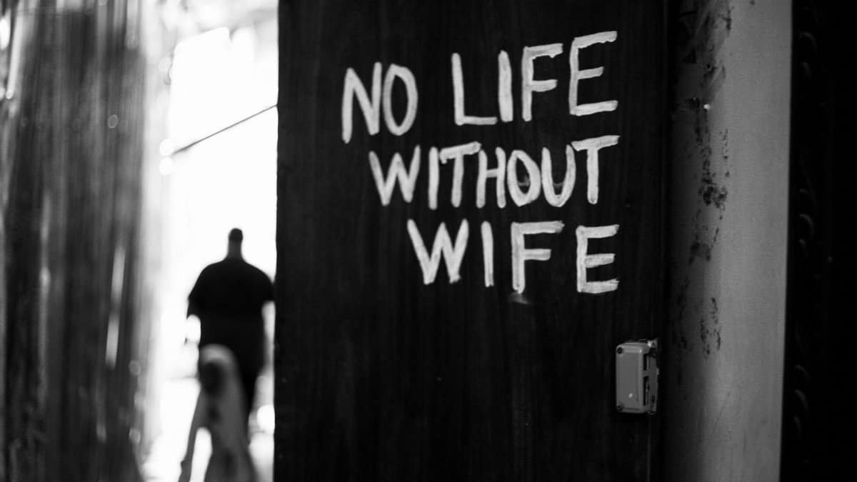 Black and white photo of a wall with 'No Life Without Wife' graffiti in Zanzibar.