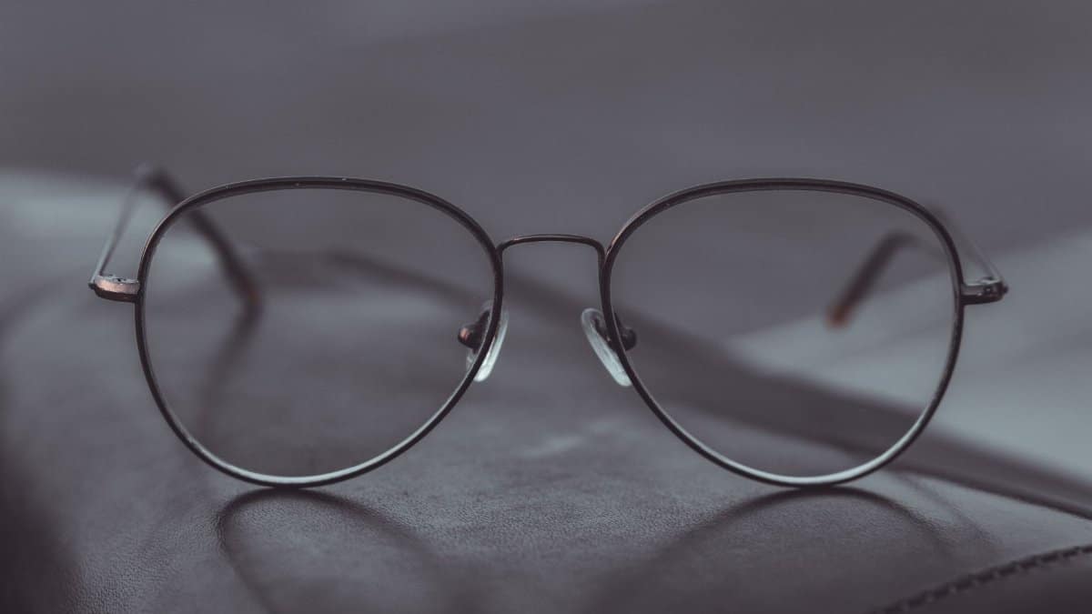 Stylish aviator glasses resting on a leather surface, showcasing sleek design.