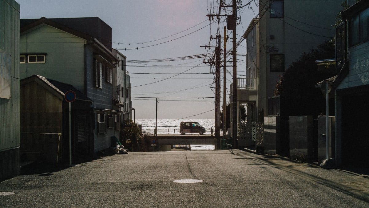 A quiet street in Kamakura, Japan, opens up to a stunning ocean view, capturing urban tranquility.