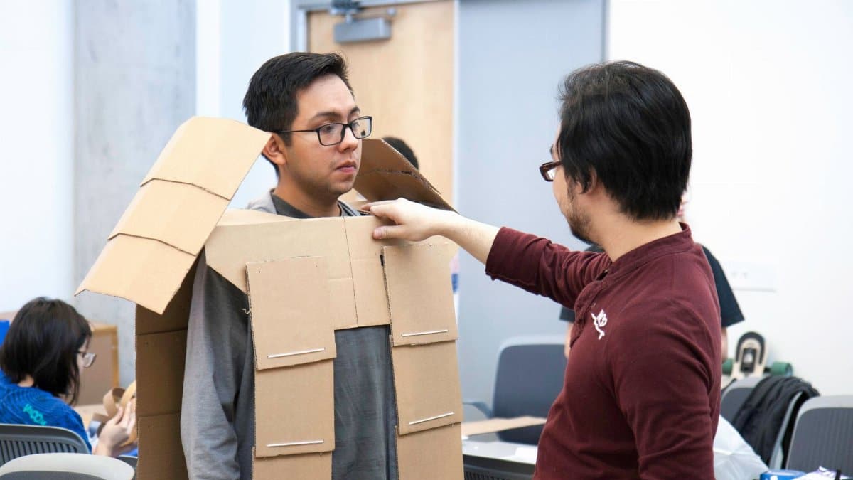 Students creating cardboard costumes in an interactive classroom environment, showcasing creativity and teamwork.