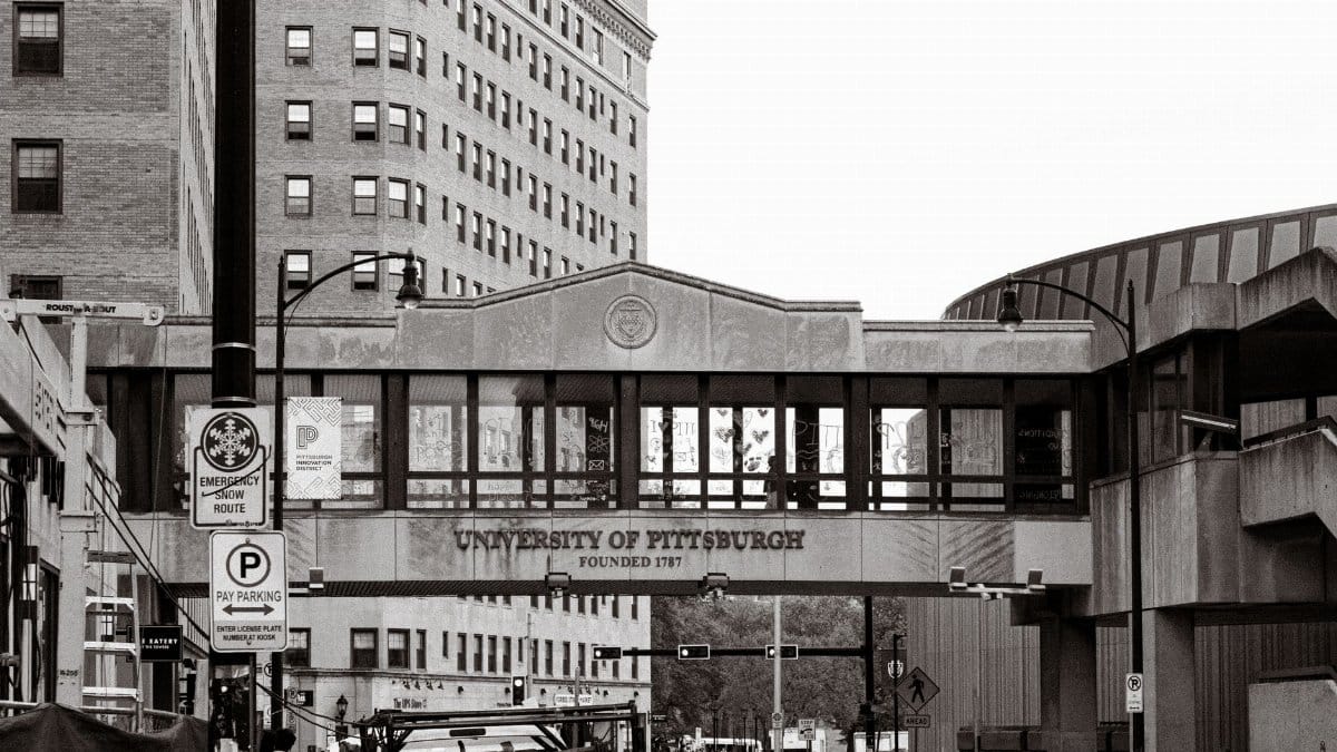Historic University of Pittsburgh campus street view with iconic architecture in black and white.