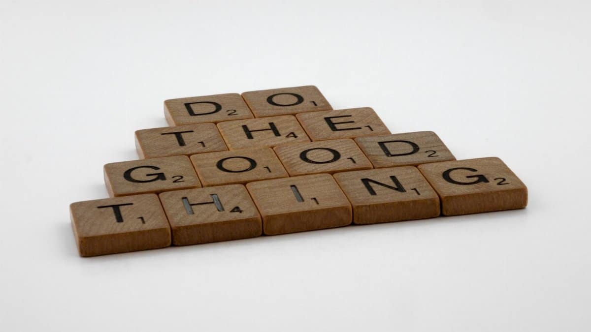 Scrabble tiles arranged to spell 'Do the good thing' on a white surface.