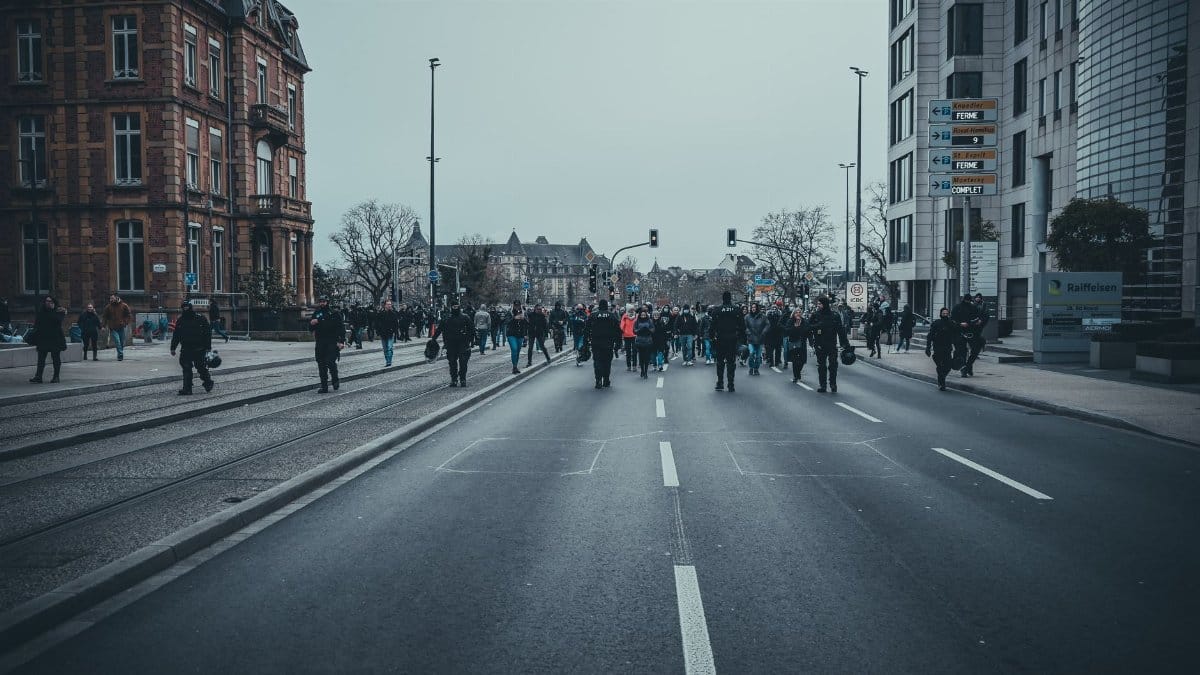 A group of people marching through the streets of Luxembourg city during a protest.