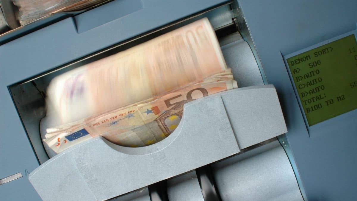 50 Euro banknotes being processed in a high-speed counting machine, showcasing technology and finance in action.
