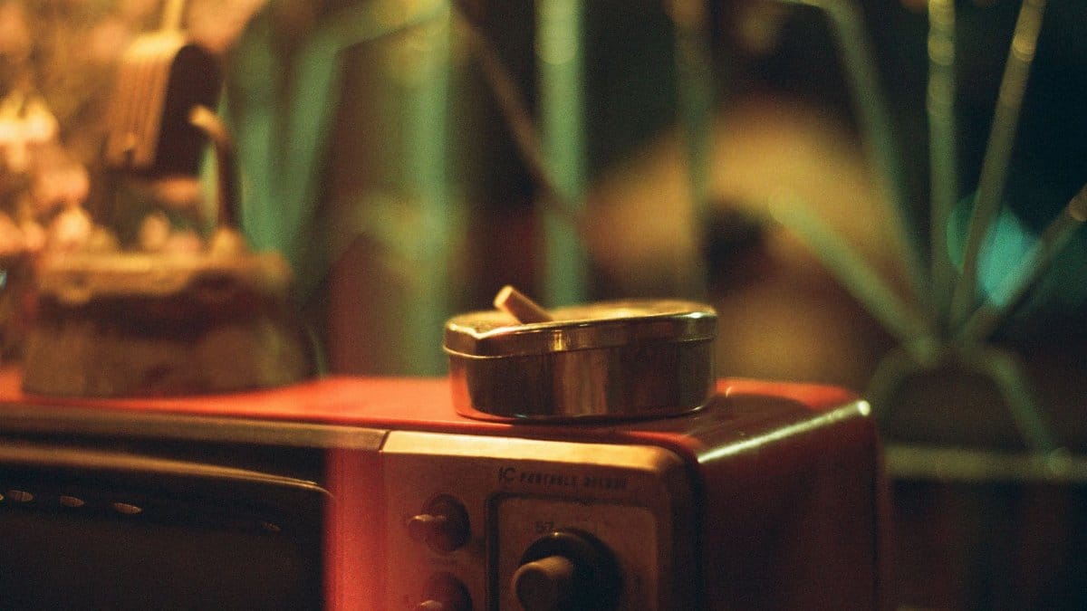 A moody close-up of an ashtray on a vintage television, evoking nostalgia and retro vibes.