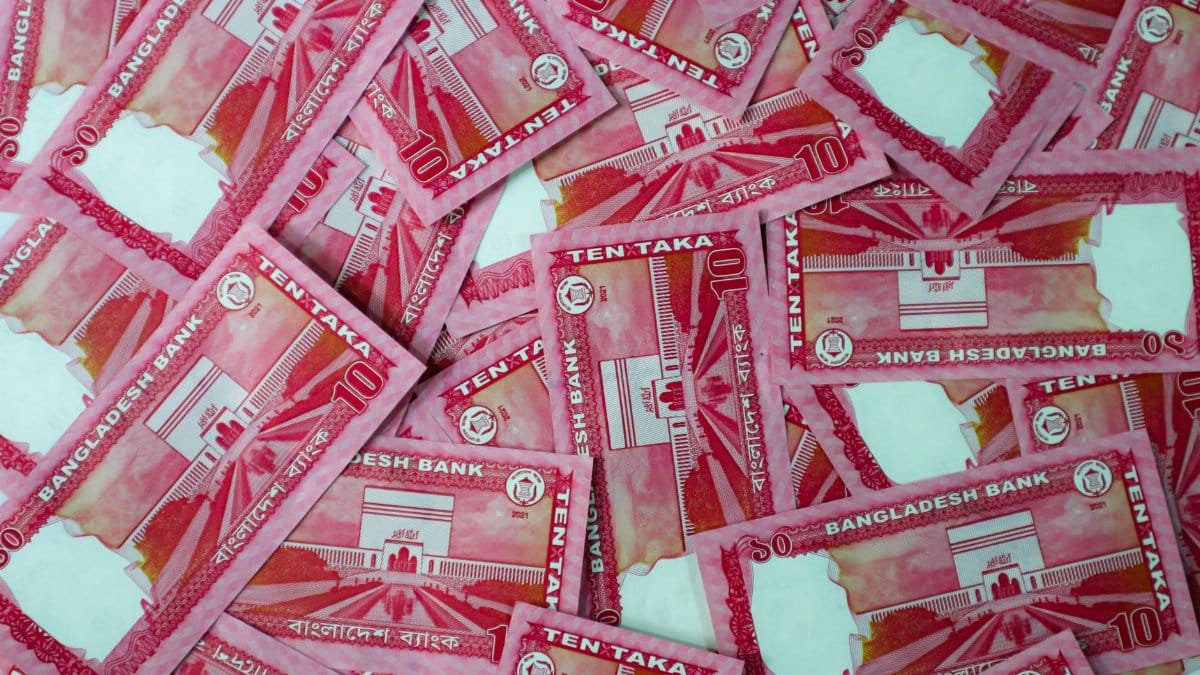 Top view of scattered ten taka Bangladeshi banknotes illustrating currency abundance.