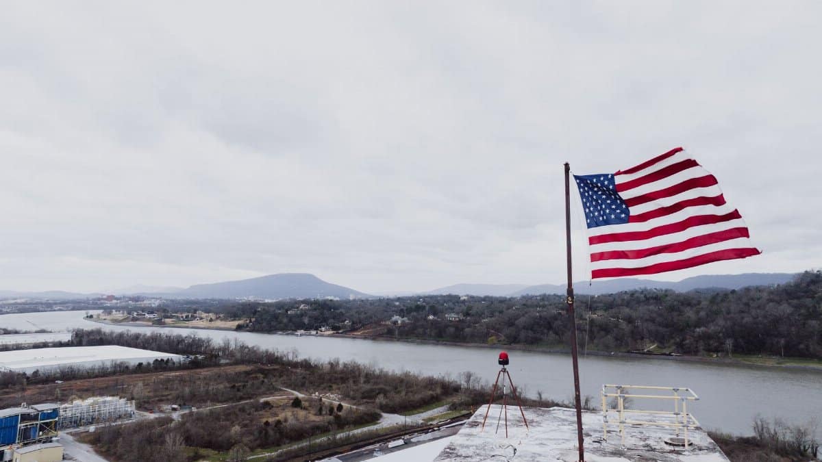 American flag waving above a scenic river in Chattanooga, Tennessee.