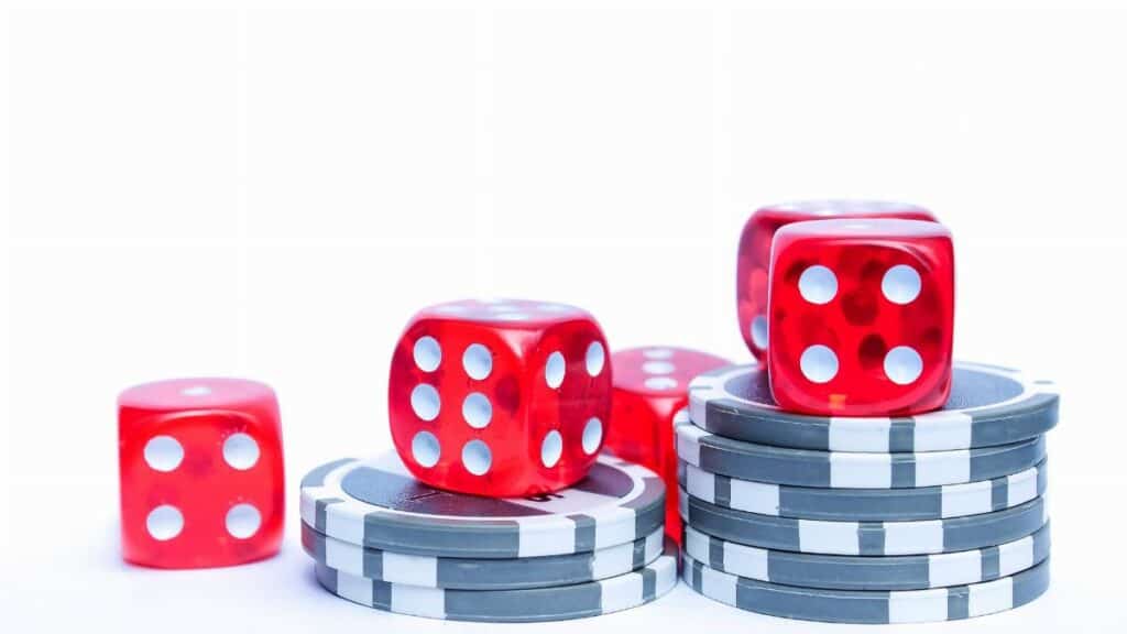 Vibrant red dice stacked with poker chips, ideal for gambling themes.