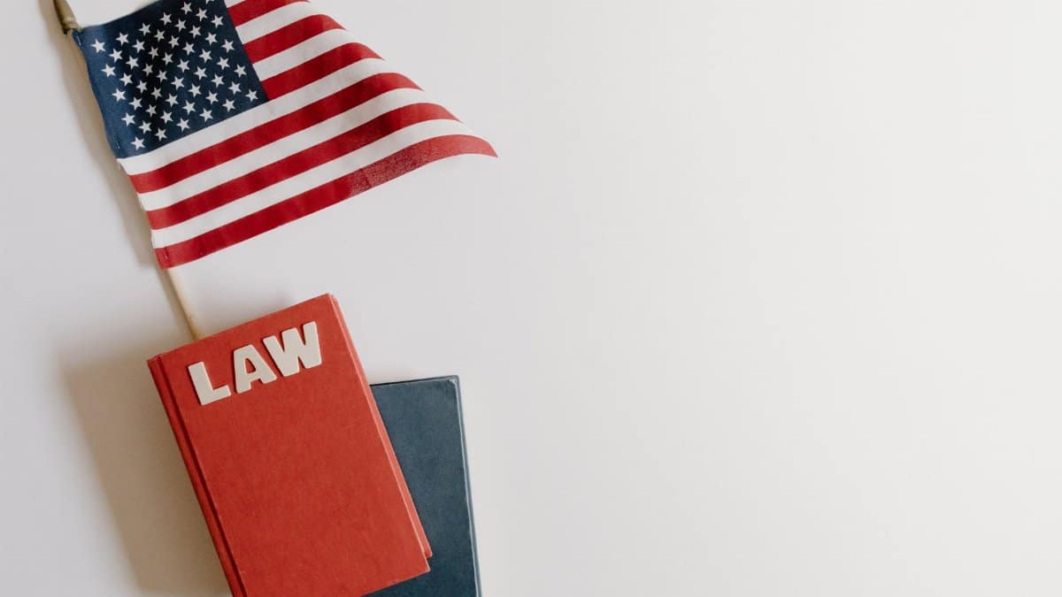 Flat lay of an American flag and a law book symbolizing justice and patriotism.