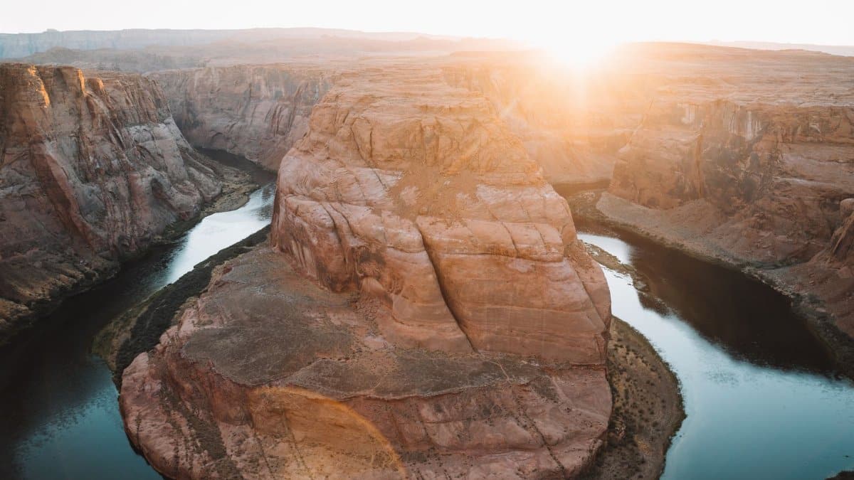A stunning aerial view of Horseshoe Bend at sunrise, showcasing the Colorado River's meander.