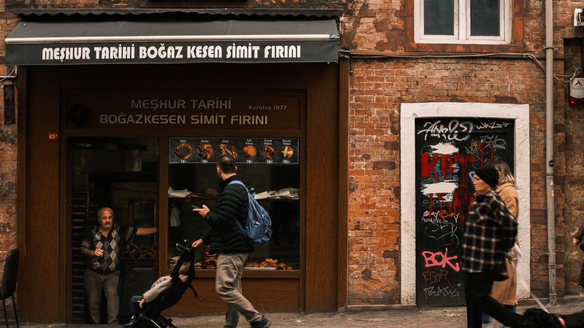 People walking past a traditional simit bakery in Istanbul, Türkiye.
