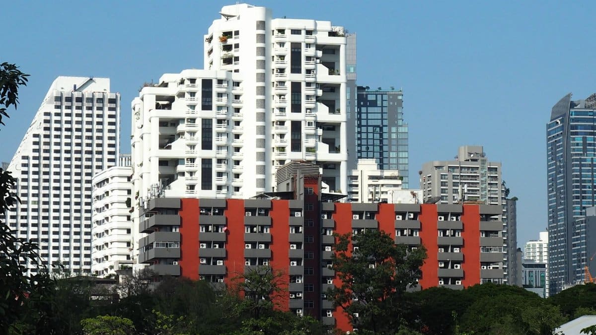 A vibrant city skyline showcasing diverse architectural styles under a clear blue sky.