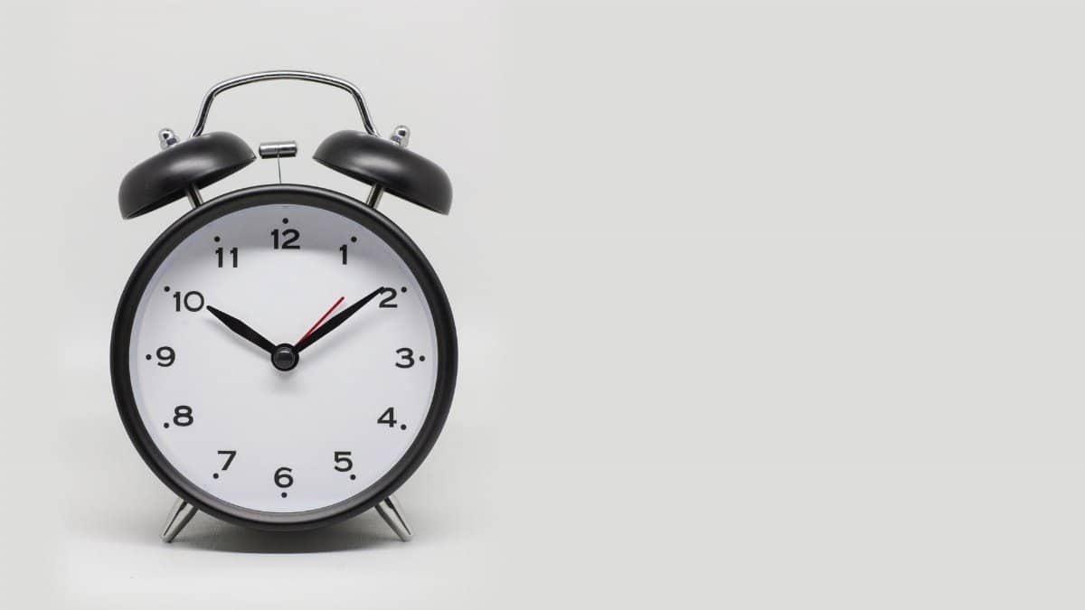 Close-up of a vintage black and white alarm clock on a white background.
